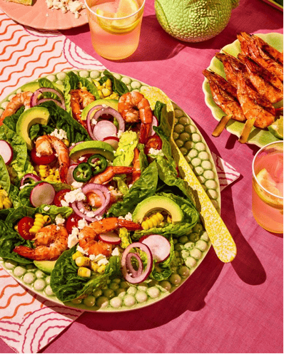Salade de crevettes et légumes sur une table rose