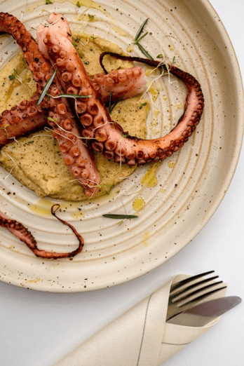 Assiette de poulpe sur une table blanche