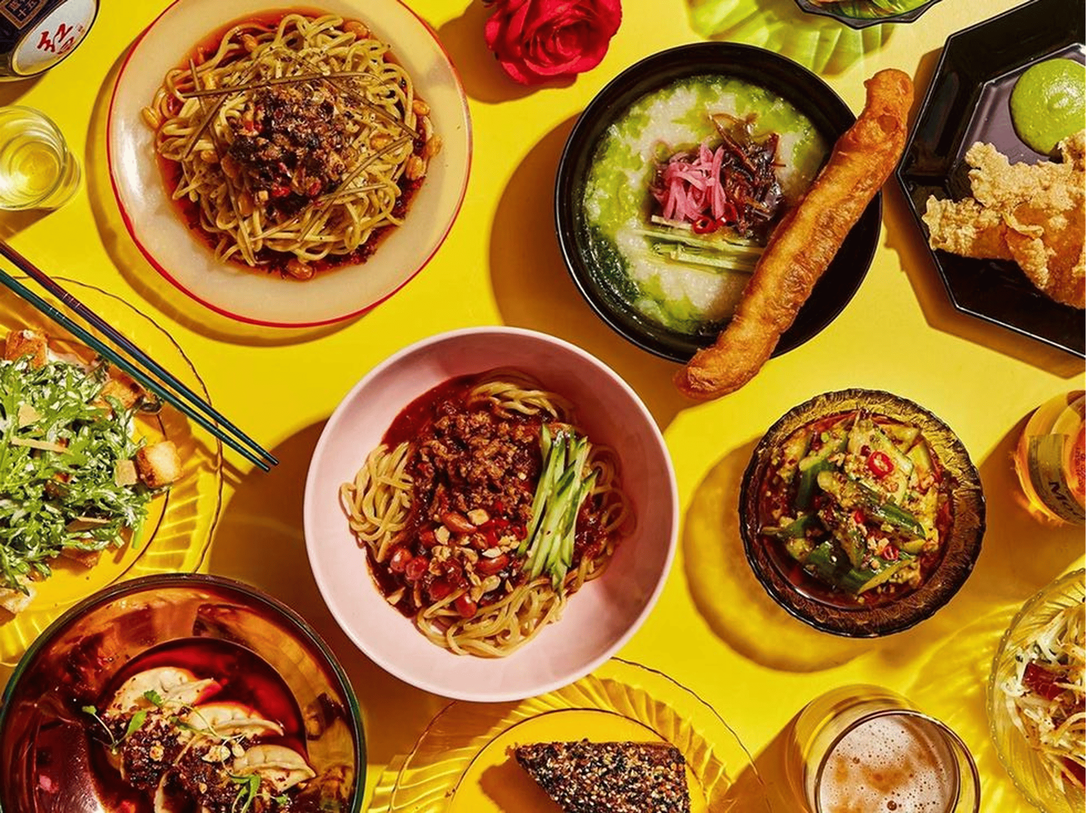 Assortiment coloré de plats partagés sur une table jaune